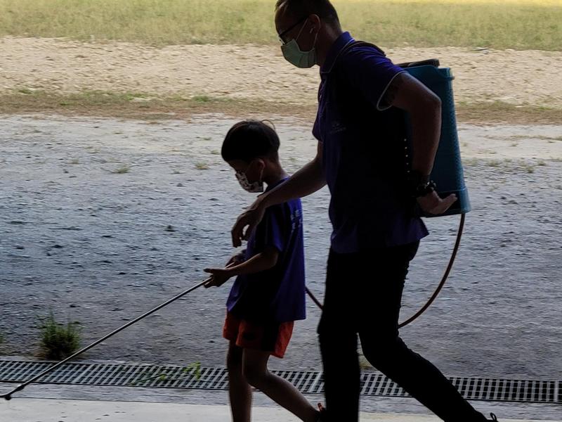 陳文靜的兒子帶著他自己的兒子在院區進行防疫消毒工作。(圖片提供：慈惠善導書院文化教育研究協會)