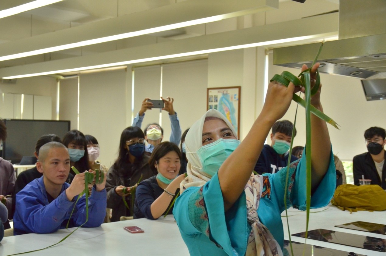 圖：東海大學的學生圍繞著印尼藝術創業家Pindy，學習Ketupat的編織技巧。（攝影／陳珈汝）